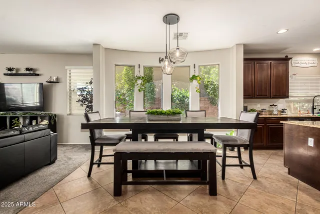a dining room with a table chairs and kitchen view