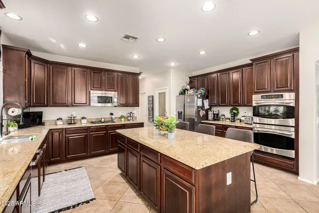 a kitchen with kitchen island granite countertop stainless steel appliances and sink