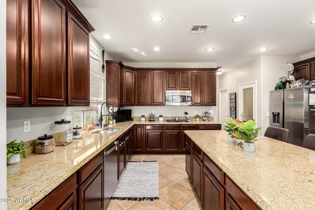 a kitchen with stainless steel appliances granite countertop counter space cabinets a sink and a center island