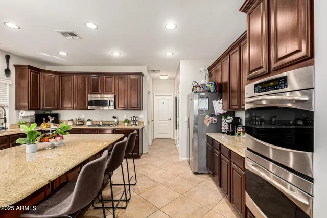 a kitchen with stainless steel appliances granite countertop a stove refrigerator sink and microwave