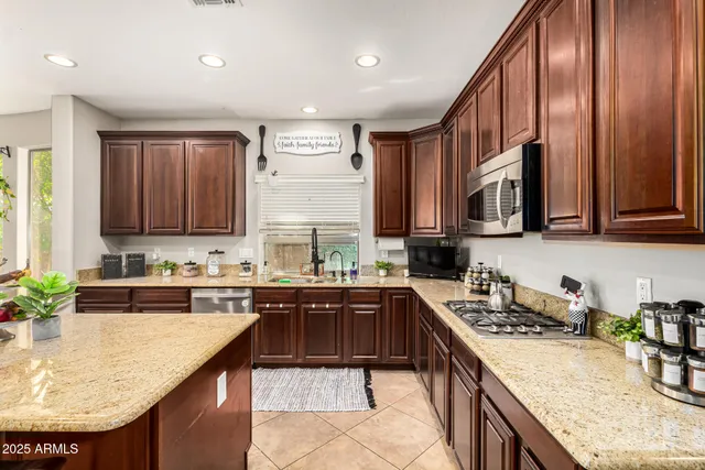 a kitchen with stainless steel appliances granite countertop a sink counter space cabinets and a large window