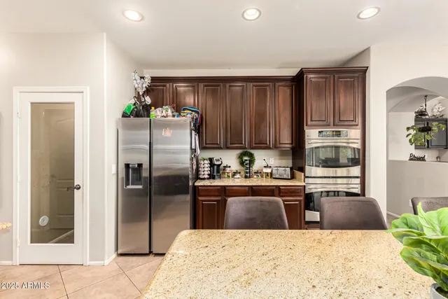 a kitchen with stainless steel appliances kitchen island granite countertop a refrigerator a stove and a sink
