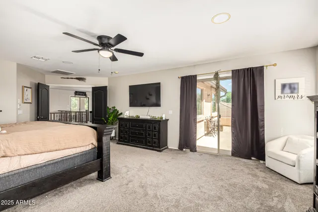 a spacious bedroom with a bed flat screen tv and a fireplace