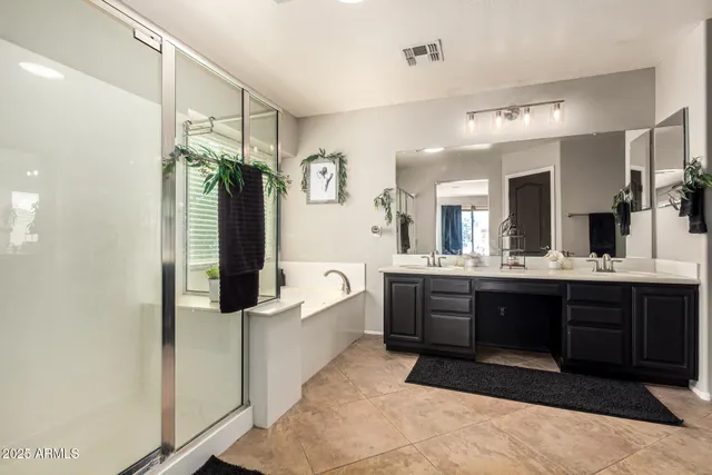 a large bathroom with a tub a double vanity sink and mirror
