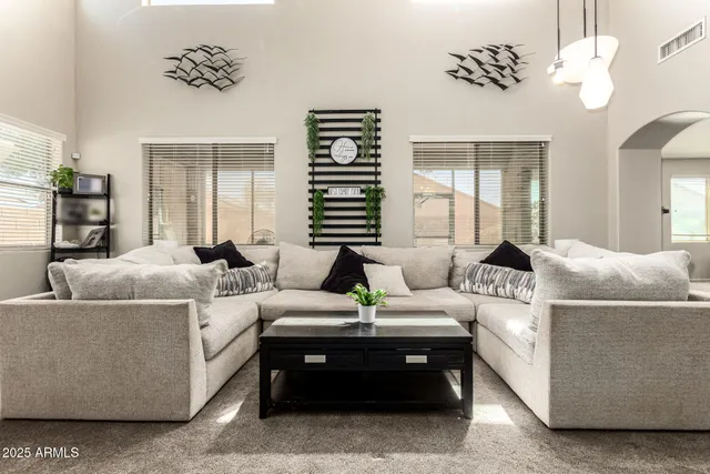 a living room with furniture a chandelier and a window