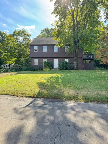 a view of a house with backyard and a tree