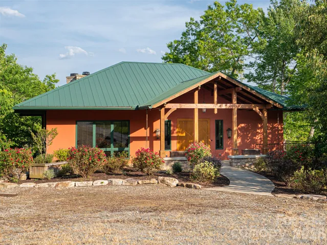 an aerial view of a house with a garden and lake view
