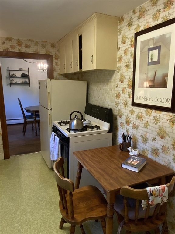 1177 Edgell Road Framingham, MA 01701 - Photo 16 of 32 a kitchen with a table chairs and a stove