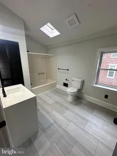 a bathroom with a toilet sink and mirror