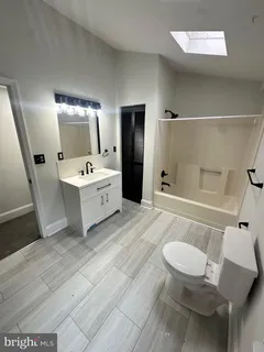 a spacious bathroom with a double vanity sink a toilet and shower