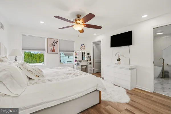 a bathroom with a white tub a sink and vanity
