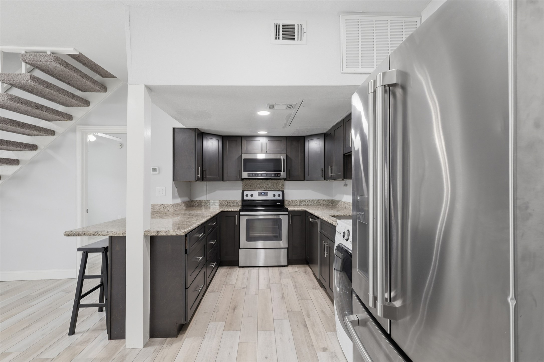 811 Threadneedle Street, Unit 287 Houston, TX 77079 - Photo 5 of 16 Updated kitchen featuring granite countertops, stainless steel appliances, and breakfast bar.
