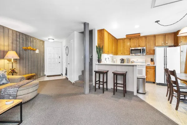 a living room with furniture a dining table and a refrigerator