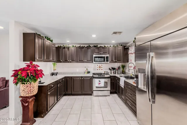 a kitchen with granite countertop a sink stainless steel appliances and cabinets