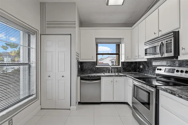 a kitchen with stainless steel appliances granite countertop a stove and a microwave