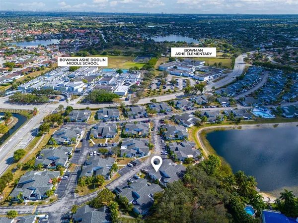 an aerial view of residential houses with outdoor space and trees