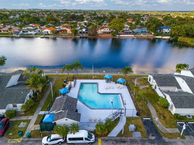 an aerial view of a house with a yard and lake view