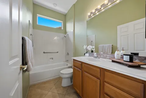 a bathroom with a granite countertop sink a toilet and shower