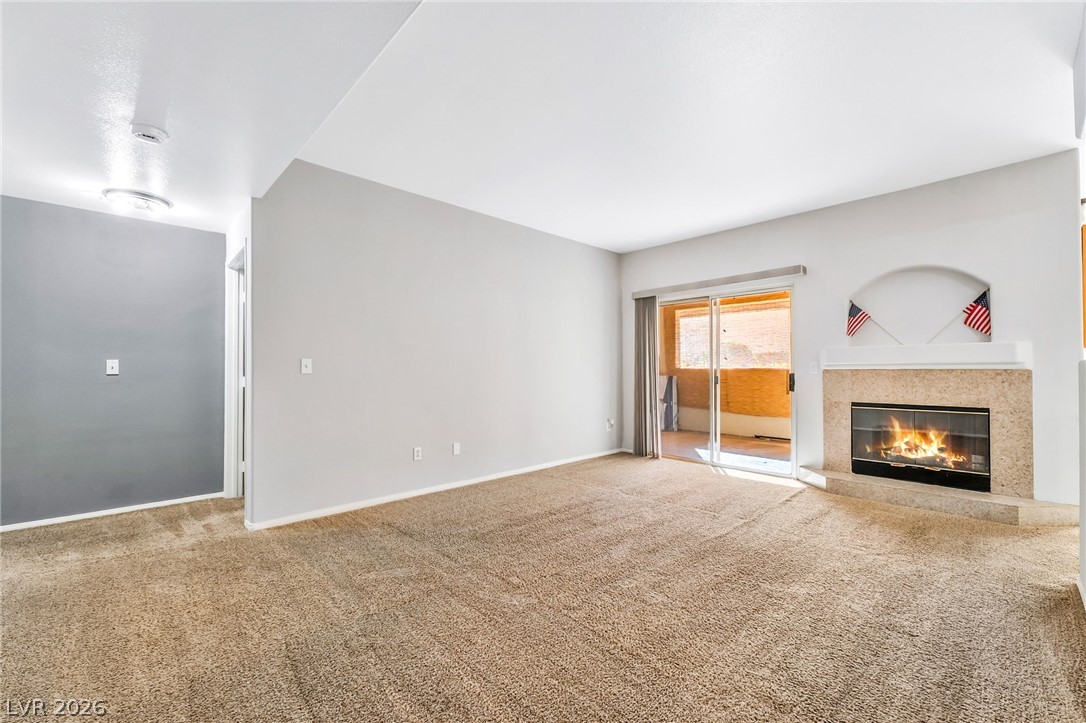 2050 West Warm Springs Road, Unit 2411 Henderson, NV 89014 - Photo 7 of 37 A cozy living space features a warming fireplace and convenient patio access.