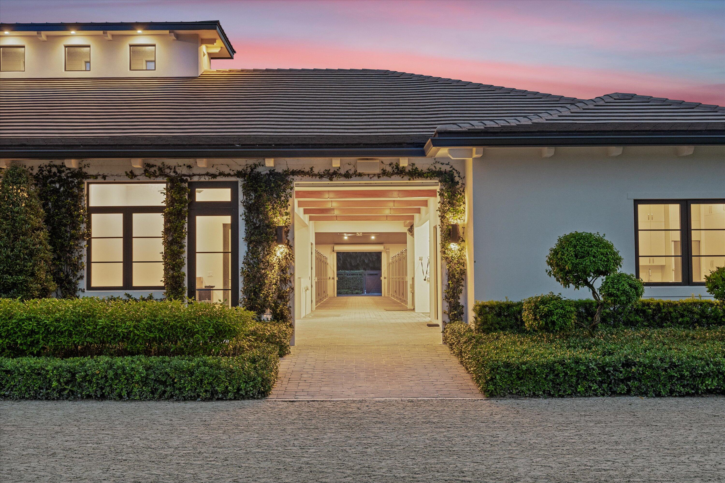 4675 Stables Way Wellington, FL 33414 - Photo 14 of 16 a front view of a house with a garden