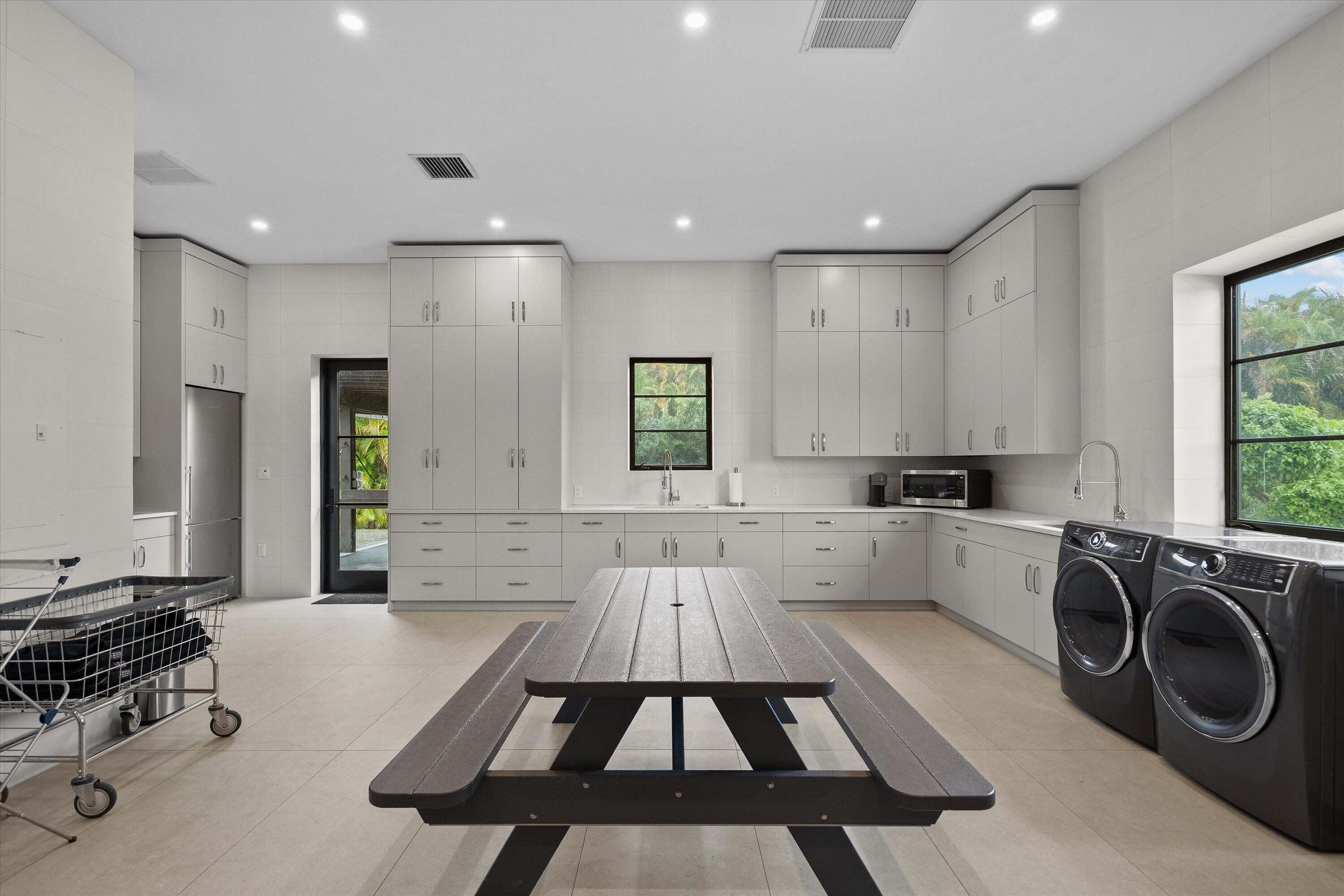 4675 Stables Way Wellington, FL 33414 - Photo 10 of 16 a large white kitchen with a stove a sink dishwasher and white cabinets with wooden floor