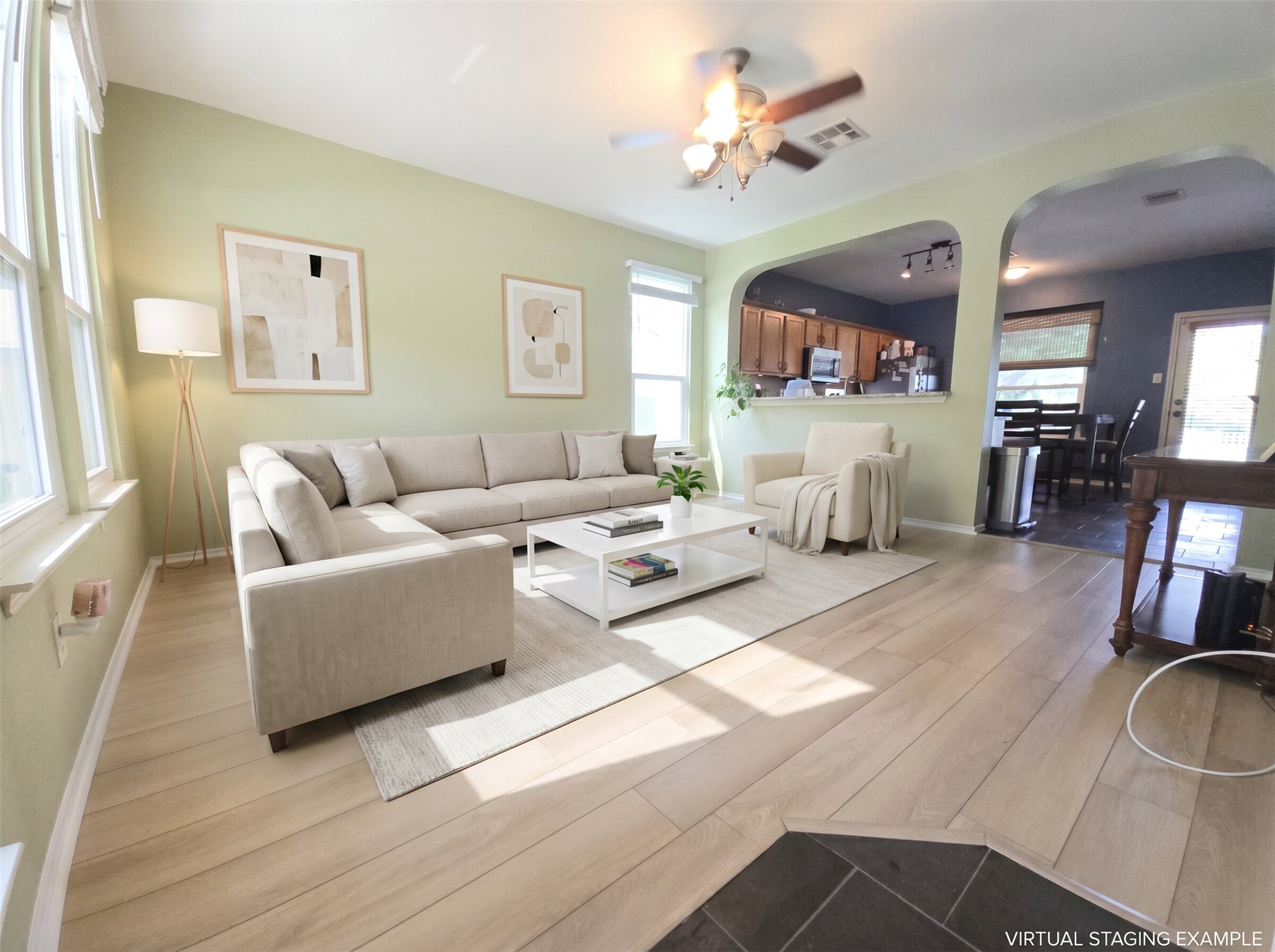 Sun-filled living area featuring light wood flooring and an inviting open-concept design.