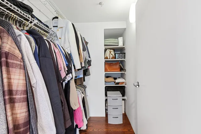 a view of walk in closet with clothes and shoes