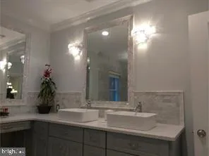 a bathroom with double vanity and a mirror