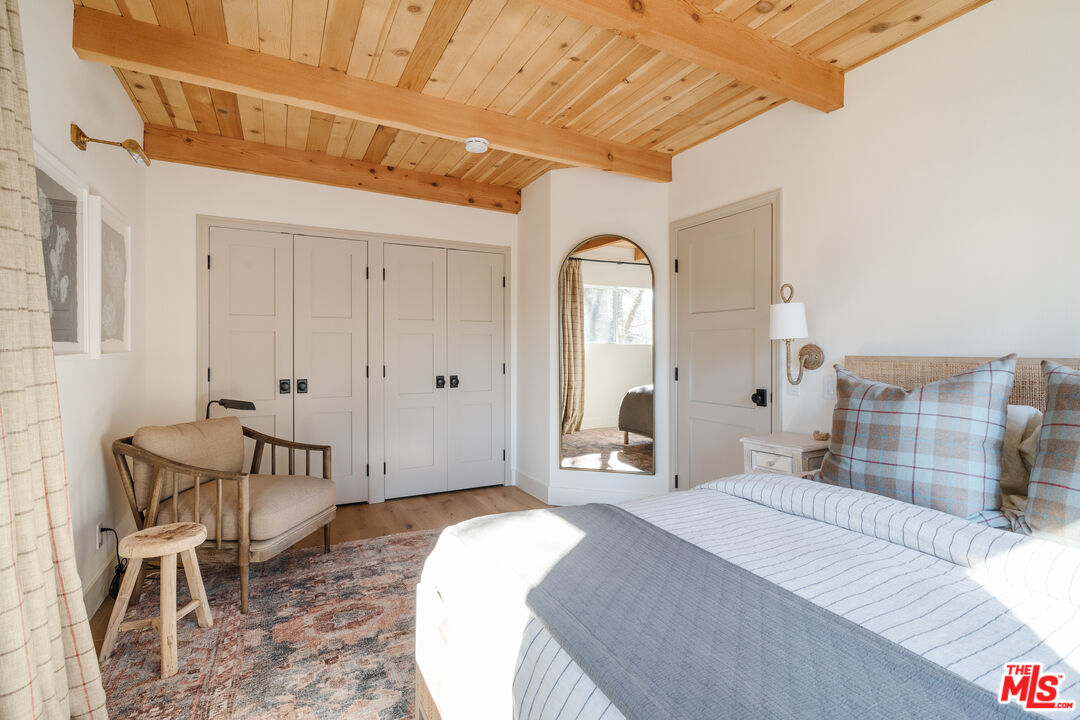 28805 North Shore Road Lake Arrowhead, CA 92352 - Photo 13 of 40 a bedroom with a bed and a chair