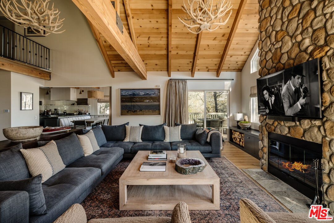 28805 North Shore Road Lake Arrowhead, CA 92352 - Photo 5 of 40 a living room with furniture a flat screen tv and a fireplace