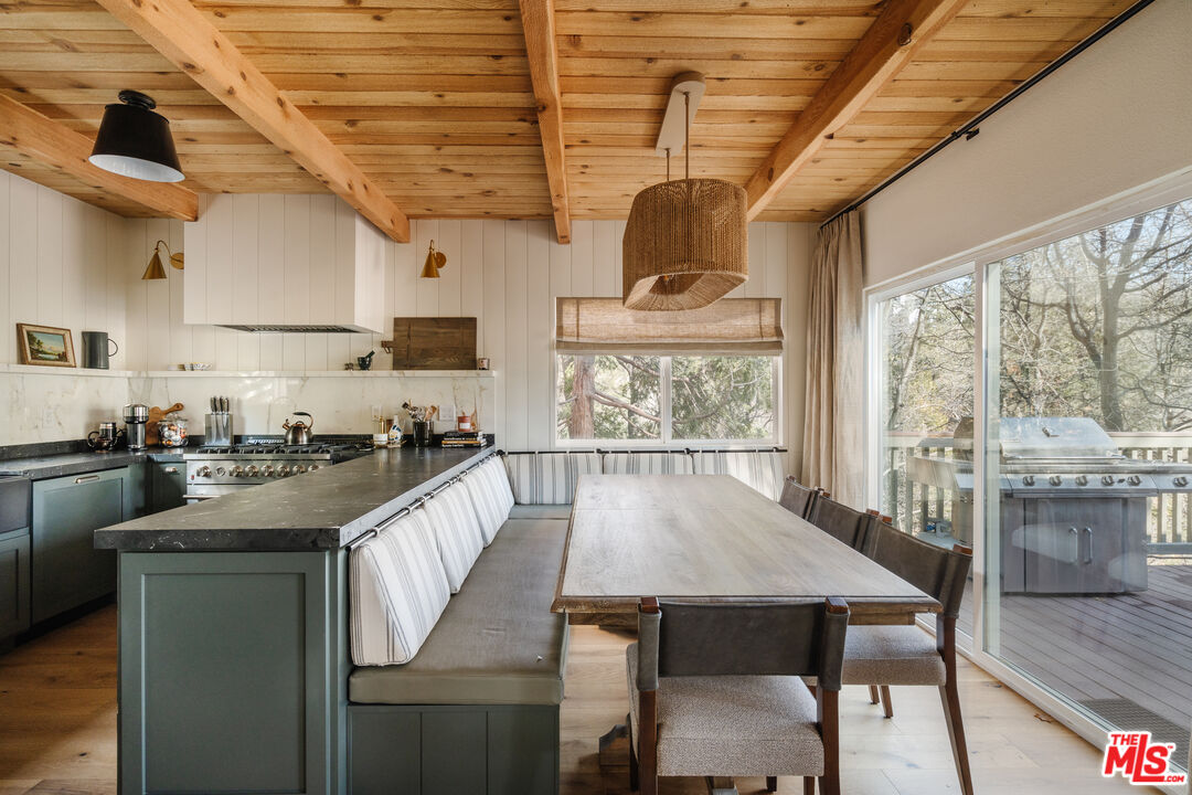 28805 North Shore Road Lake Arrowhead, CA 92352 - Photo 9 of 40 a kitchen with a table chairs stove and cabinets