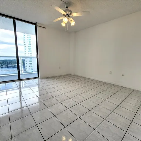 en empty room with windows and ceiling fan