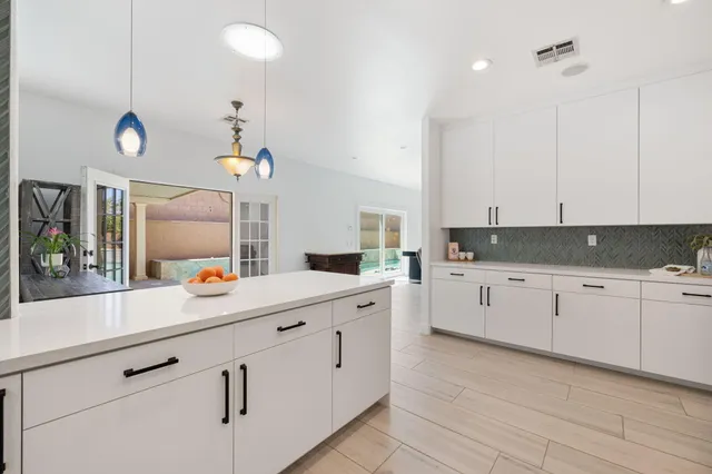 a kitchen with white cabinets and sink