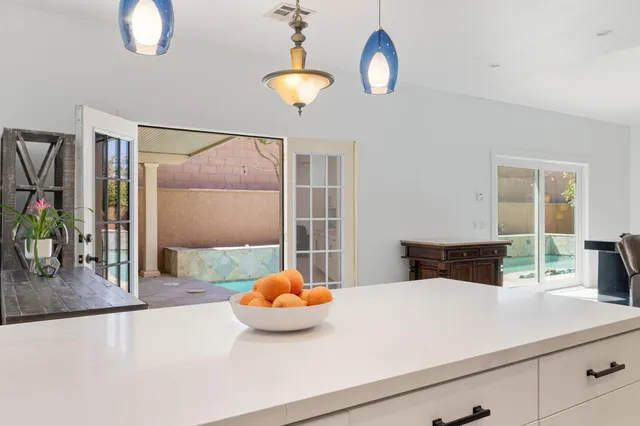 a kitchen with a sink a counter space and a chandelier