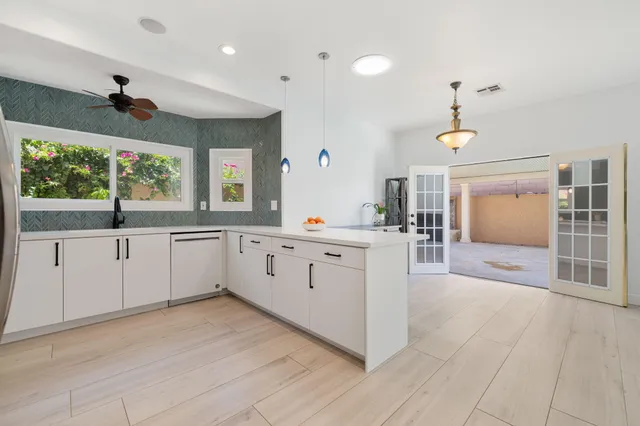 a large white kitchen with a large window