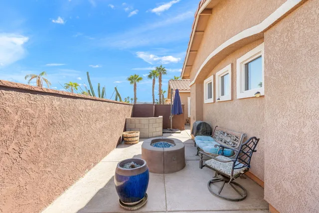 a view of a patio with chairs and potted plants