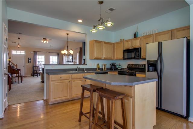 3003 Hope Circle Spring Hill, TN 37174 - Photo 8 of 20 15X11 kitchen has double-bowl stainless steel sink, electric stove, UPGRADED LIGHTING, and 2-stool ISLAND with additional cabinets. Great home for entertaining or just chatting with family in living room...while cooking and sharing TV