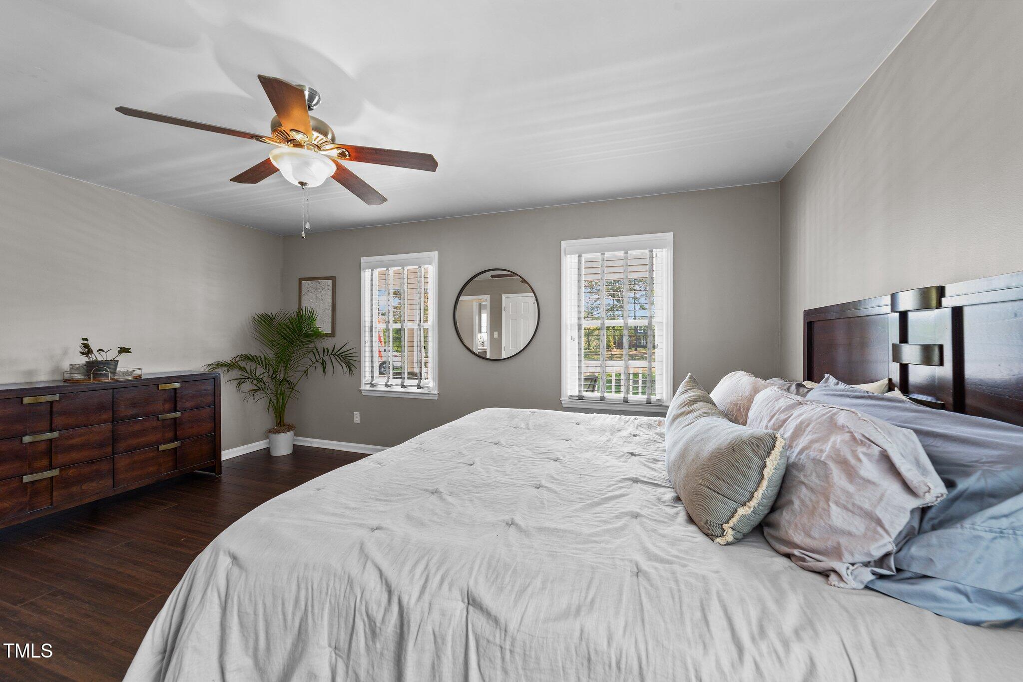 8700 Crowder Road Raleigh, NC 27603 - Photo 17 of 36 a bedroom with a large bed and a chandelier