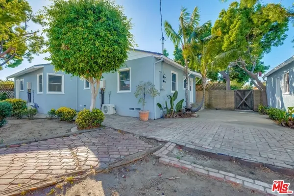 a view of a house with a yard and large tree