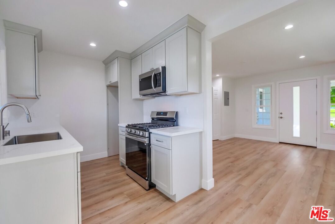 8356 Kittyhawk Avenue Los Angeles, CA 90045 - Photo 1 of 24 a kitchen with stainless steel appliances granite countertop a sink stove and microwave