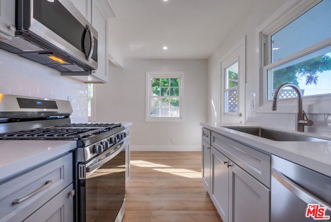 8356 Kittyhawk Avenue Los Angeles, CA 90045 - Photo 12 of 24 a kitchen with stainless steel appliances granite countertop a stove a sink and a microwave