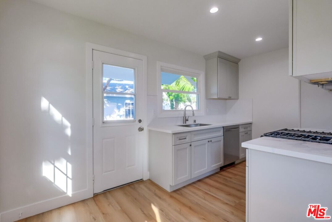 8356 Kittyhawk Avenue Los Angeles, CA 90045 - Photo 7 of 24 a kitchen with white cabinets and sink