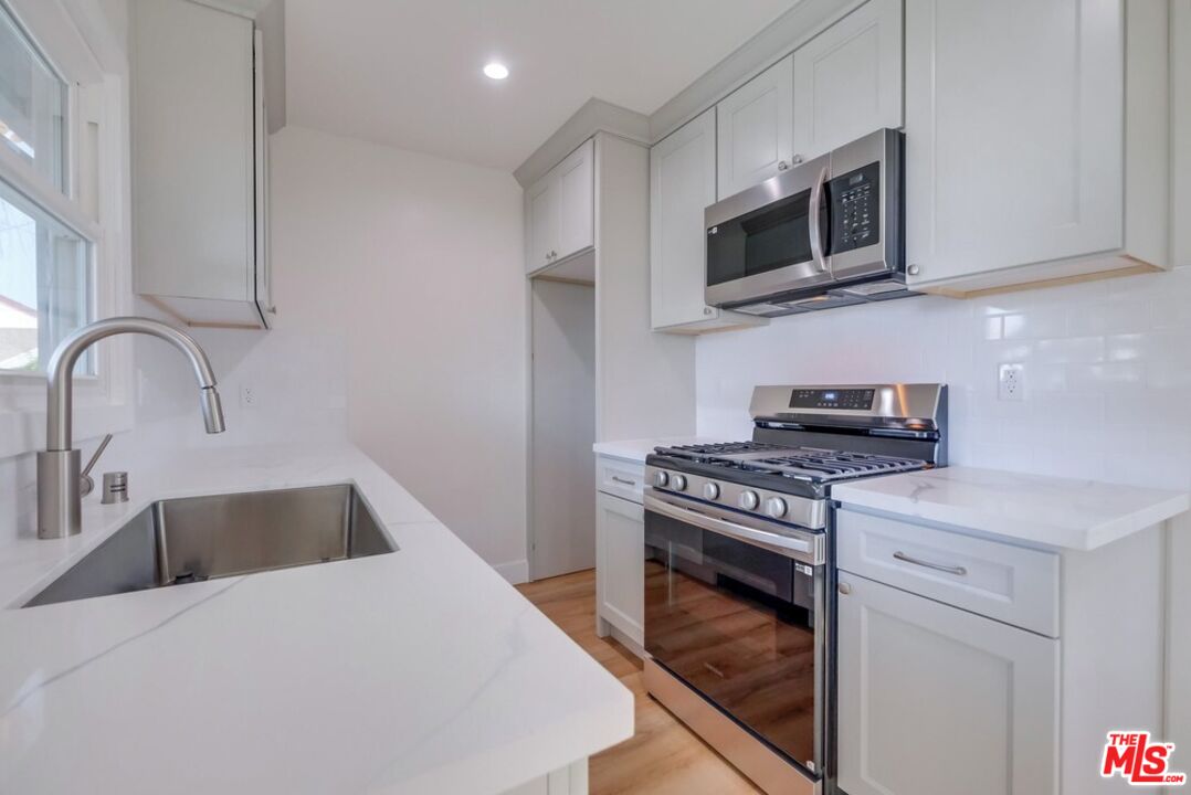 8356 Kittyhawk Avenue Los Angeles, CA 90045 - Photo 9 of 24 a kitchen with stainless steel appliances granite countertop a sink a stove and microwave