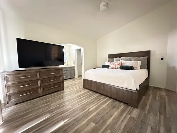 a bedroom with a bed and a flat screen tv