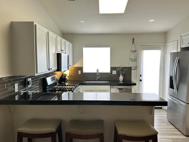 a kitchen with a table chairs refrigerator and microwave