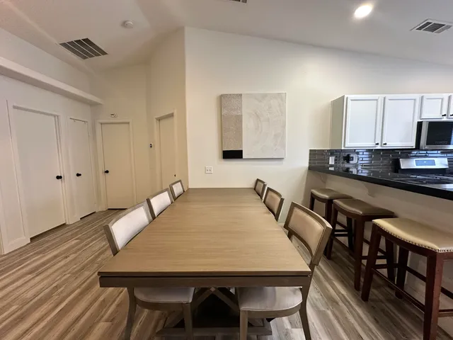 a view of a a dining room with furniture window and wooden floor