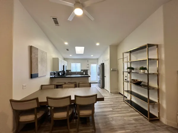 a dining area with a table chairs and a kitchen view