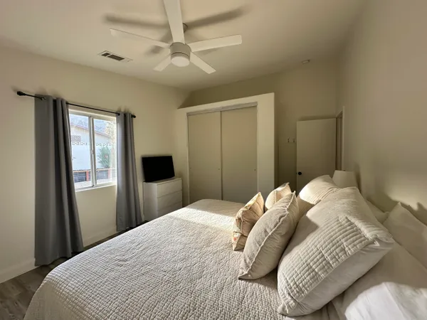 a bedroom with a large bed and a chandelier