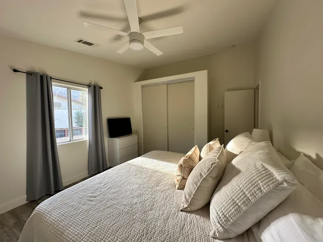 a bedroom with a large bed and a chandelier