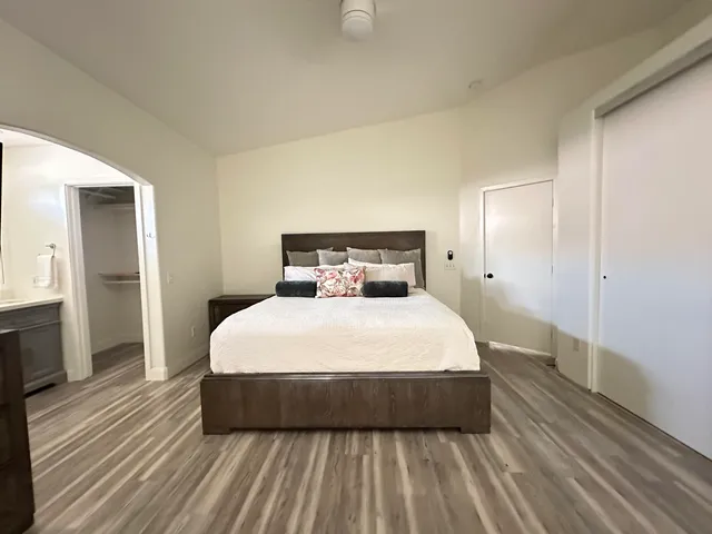 a bedroom with a bed and wooden floor